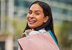 Shopping bag, retail and woman in the city for a sale in New York for a discount or store at a mall. Face portrait of a happy, young and rich girl with bags after shopping during luxury sales in town