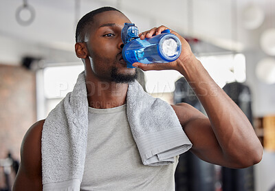 Buy stock photo Water, drink and fitness with a sports man in a gym for exercise while taking a break to hydrate. Workout, training and drinking with a male athlete taking a sip from a bottle after his routine