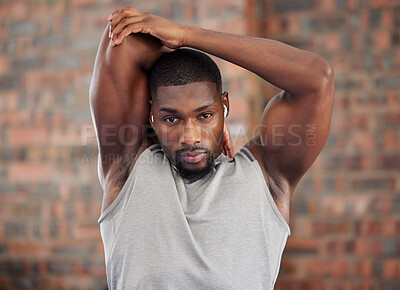 Buy stock photo Fitness, stretching and earphones with man in gym for health, workout and listening to music. Exercise, energy and wellness with portrait of young athlete training with sports, podcast and power 