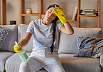 Spring cleaning, tired and sad woman headache in home living room with burnout, stress and frustrated spray task. Fatigue, pain and depression, housekeeping cleaner and exhausted maid service problem