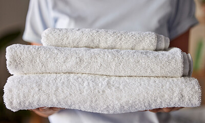 Buy stock photo Woman, towels or laundry cleaning for hotel housekeeping maid, home cleaner service or relax resort worker. Zoom, texture or fabric cloth in hospitality hygiene maintenance or washing machine process