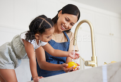 Buy stock photo Cleaning, mother and child washing vegetables with water for lunch, nutrition or breakfast in the kitchen of their house. Child learning to clean food while cooking with her mom before dinner