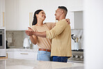 Love, smile and couple dance in kitchen, celebrating anniversary and bonding. Happy, man and woman dancing, romance and affection, carefree or playful people having fun spending time together in home