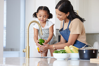 Buy stock photo Kitchen, mother and child washing vegetable to cook dinner, lunch or breakfast together at house. Happiness, bonding and mom cleaning a green pepper before cooking food with girl kid in family home.