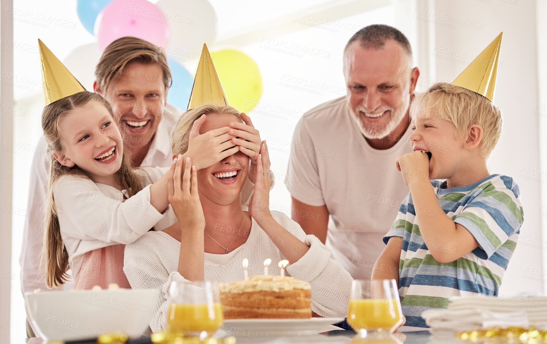 Buy stock photo Surprise, mother birthday and family celebrate at a party at home with a happy smile. Mama, father and children with happiness and excited joy in a house with event food, cake and candles for mom