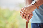 Disability, senior man and hands on stick for support while walking in a retirement home. Disabled, Handicap and elderly male patient holding a walk aid or cane in a healthcare nursing facility.