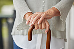 Hands, walking cane and senior woman with disability leaning for help, balance and support at nursing or retirement home. Hand, mature and mobility stick for disabled elderly lady in physical therapy
