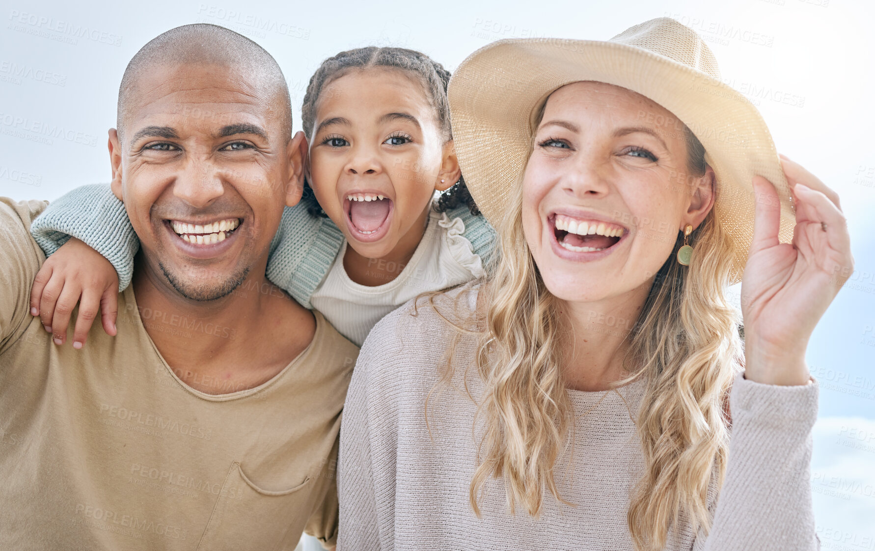 Buy stock photo Summer, blue sky and portrait of young family having fun, laugh and play together. Multicultural mom, dad and girl outdoors on beach holiday and vacation. Love, bonding and couple with kid on weekend