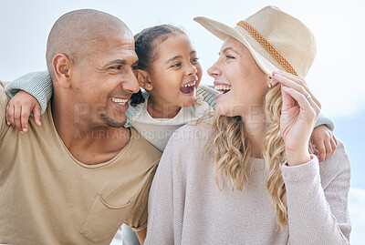 Buy stock photo Happy, child and interracial parents at the beach for a holiday in summer in Indonesia together. Smile, playful and mother and father with care and affection for girl at the ocean on a vacation