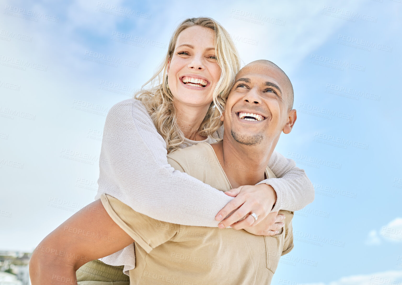 Buy stock photo Woman, interracial couple and piggy back with love, happiness and fun in the sun outdoor. Happy people relationship with a smile in the sunshine together on travel and summer vacation with a blue sky