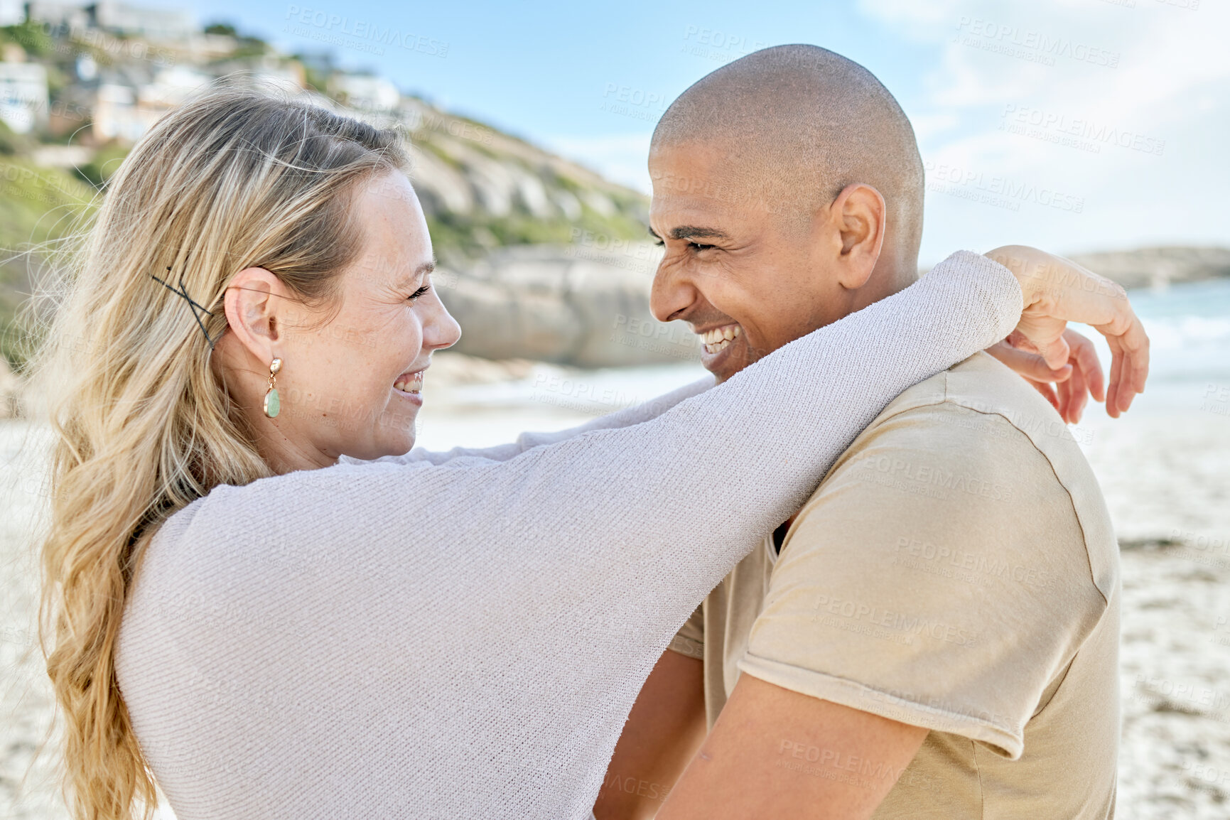 Buy stock photo Couple, love and hug on the beach smile for romantic date, anniversary or engagement announcement. Happy people show commitment care, happiness and trust by the sea and ocean water together