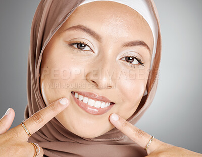 Buy stock photo Beauty, muslim and woman with teeth portrait pointing at healthy smile with fingers closeup. Happy face of beautiful girl with hijab smiling with confidence for dental care in grey studio.