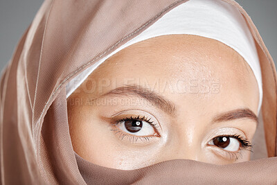Buy stock photo Muslim, eye and beauty with face of woman for health lashes, makeup and vision in grey background. Youth, cosmetics and skincare with islamic girl and zoom in stare for hijab, serious or religion