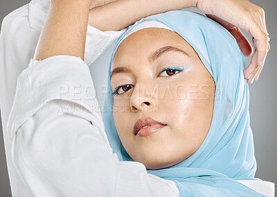 Buy stock photo Muslim, woman and face in beauty makeup or cosmetics with hijab against a grey studio background. Portrait of beautiful female model wearing blue scarf posing for fashion, style or islamic culture