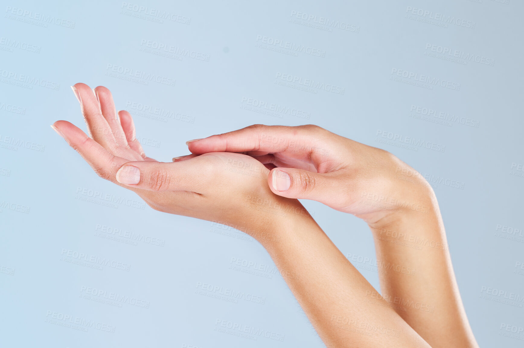 Buy stock photo Skincare, beauty and manicure with hands of woman and massage palm for wellness, health and spa against a blue background in studio. Salon, cosmetics and luxury with girl hand for clean dermatology