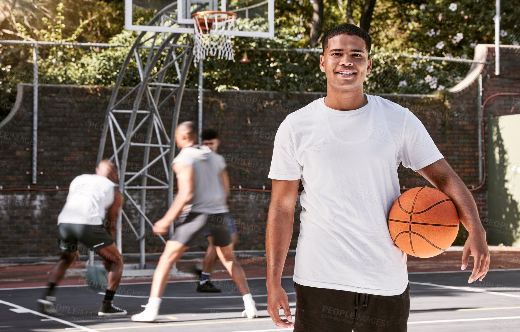 Buy stock photo Portrait of african man, basketball and athlete on basketball court outdoors. Basketball player, fitness and healthy sports training on court in urban city with teammates playing in background