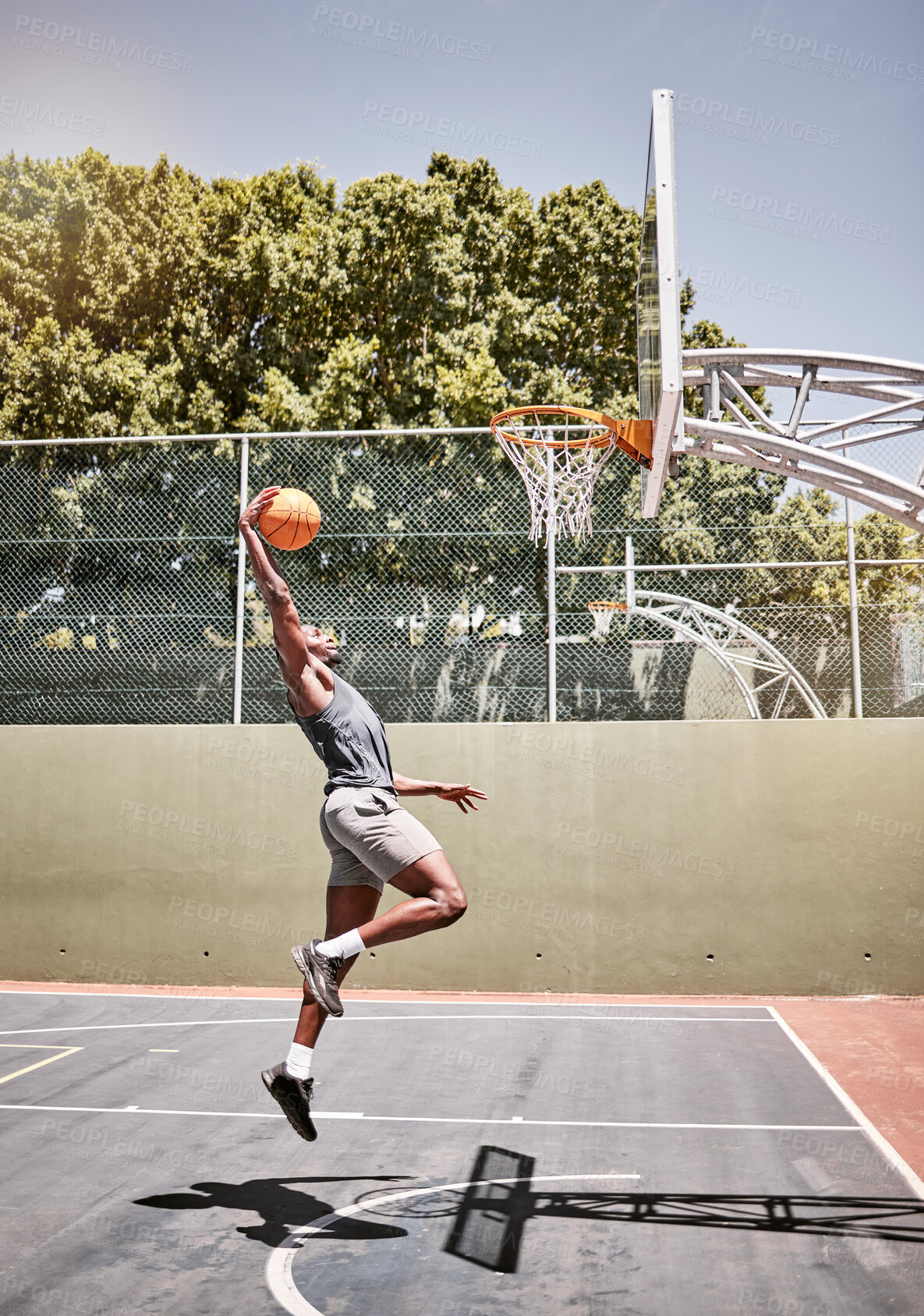 Buy stock photo Basketball, sports and jump with man on court playing games for fitness, training and health. Energy, exercise and workout with basketball player in outdoor for wellness, summer and athlete lifestyle