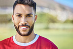 Soccer player, portrait and man on soccer field happy, smile and excited about sports win at outdoor pitch. Indian football player, fitness and face of athlete guy at football training after workout