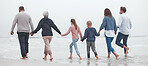Big family, holding hands and walking on beach for vacation or quality bonding time together in nature. Hand of parents, grandparents and kids enjoying travel, freedom and family fun  on ocean water