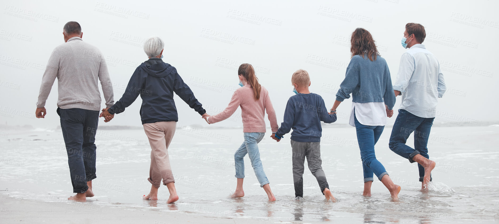 Buy stock photo Big family, holding hands and walking on beach for vacation or quality bonding time together in nature. Hand of parents, grandparents and kids enjoying travel, freedom and family fun in ocean water