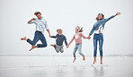 Family, funny and jumping on the beach together while on holiday. Happy family with children, parents and holding hands and jump, fun and smile with love during travel vacation in the Netherlands 
