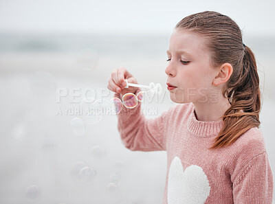 Buy stock photo Girl, fun and blowing soap bubbles with fun, freedom and vacation at the beach. A young female playing and relaxing on her holiday outdoor at the sea in with a toy to play, entertain and free outside