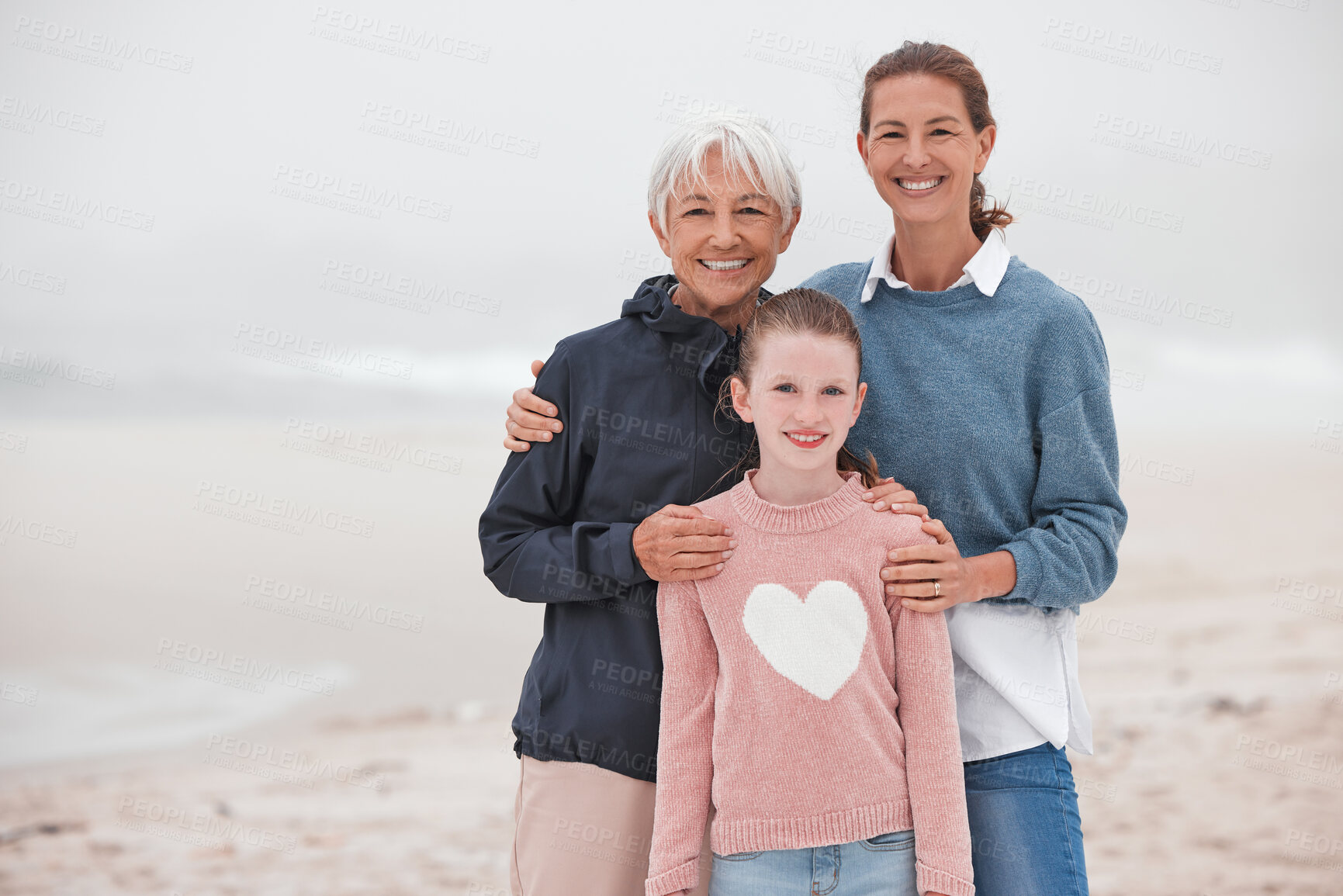 Buy stock photo Mother, grandma and child at beach in portrait, bonding or love in winter, mist or cloud by sea. Mom, girl and senior for smile, happy or care in family, happiness or together at ocean on vacation