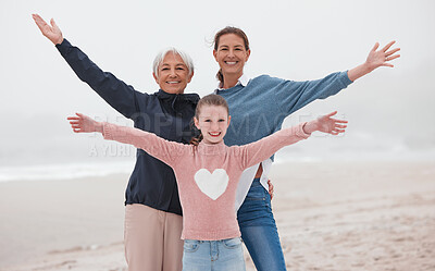 Buy stock photo Family, love and beach with a girl, mother and grandmother on the sand by the sea or ocean during a vacation together. Travel, love and nature with a senior woman, daughter and grandchild on holiday