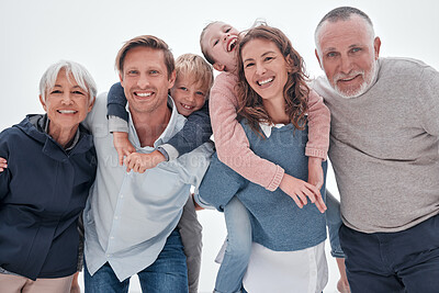 Buy stock photo Happy big family, portrait and piggy back on holiday, vacation or trip against cloudy sky. Love, care and man, woman and children with grandparents bonding outdoors together in misty winter weather.
