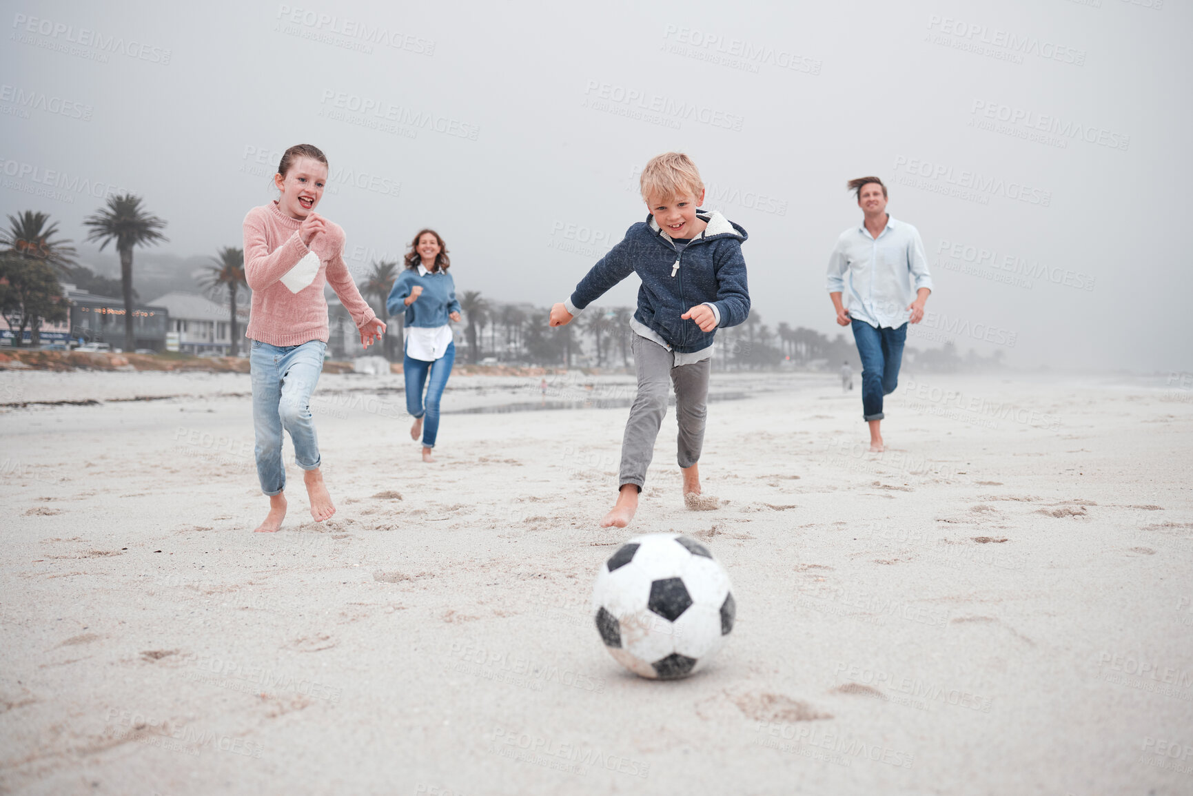 Buy stock photo Soccer, summer beach activity and family running and playing  with energy and happiness. Happy sea sport and football game with mom, dad and children on sand with a smile on vacation with kids