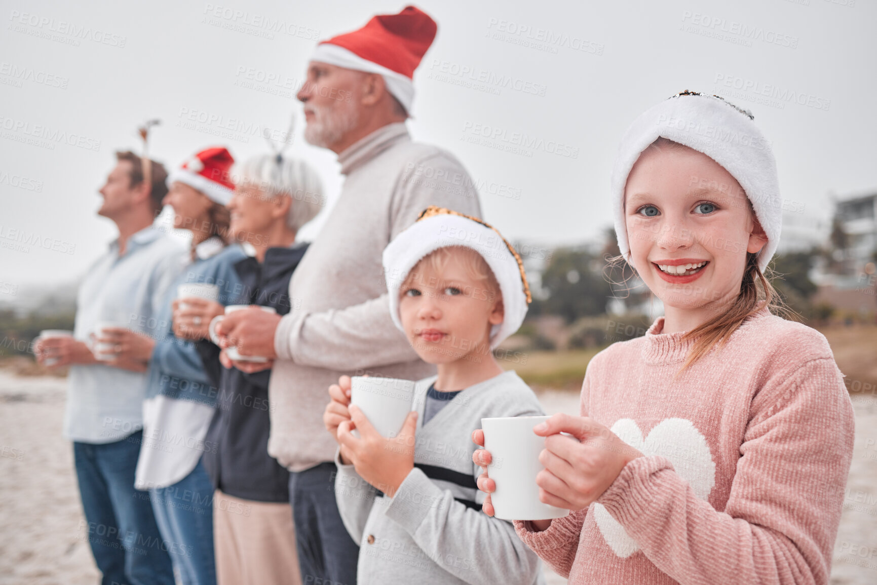 Buy stock photo Family, generations and Christmas, drink and view outdoor while on vacation, holiday and festive time at the beach. Parents, grandparents and children, happy with hot chocolate, mug and xmas hat.