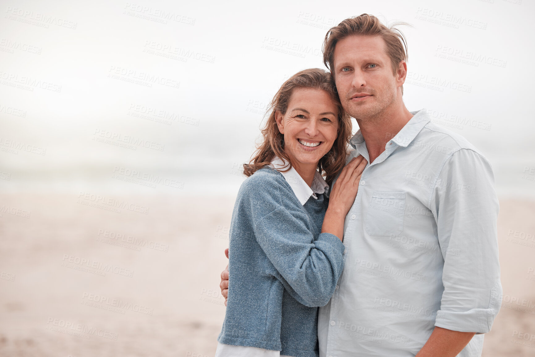 Buy stock photo Happy, couple and portrait smile on a beach together relaxing while enjoying quality bonding time in the outdoors. Man and woman smiling in happiness for hug, relationship love or care on sandy ocean
