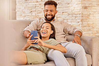 Buy stock photo Couple, lounge and phone of people on a house sofa with technology watching a video or funny meme. Streaming, social media and internet scroll of a girlfriend and boyfriend in a living room laughing