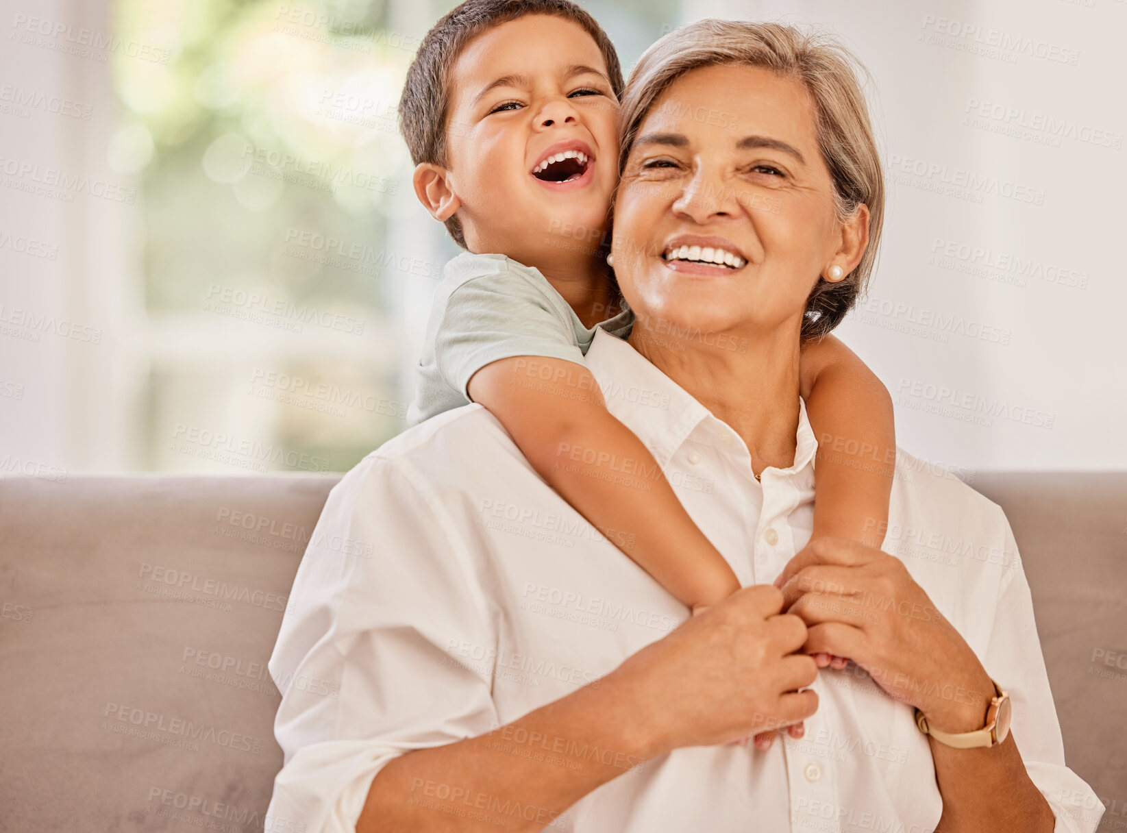 Buy stock photo Grandmother, kid and happy family hug bonding together on a home living room couch. Elderly woman, child and smile of people spending quality time hugging to show love and care on a house sofa