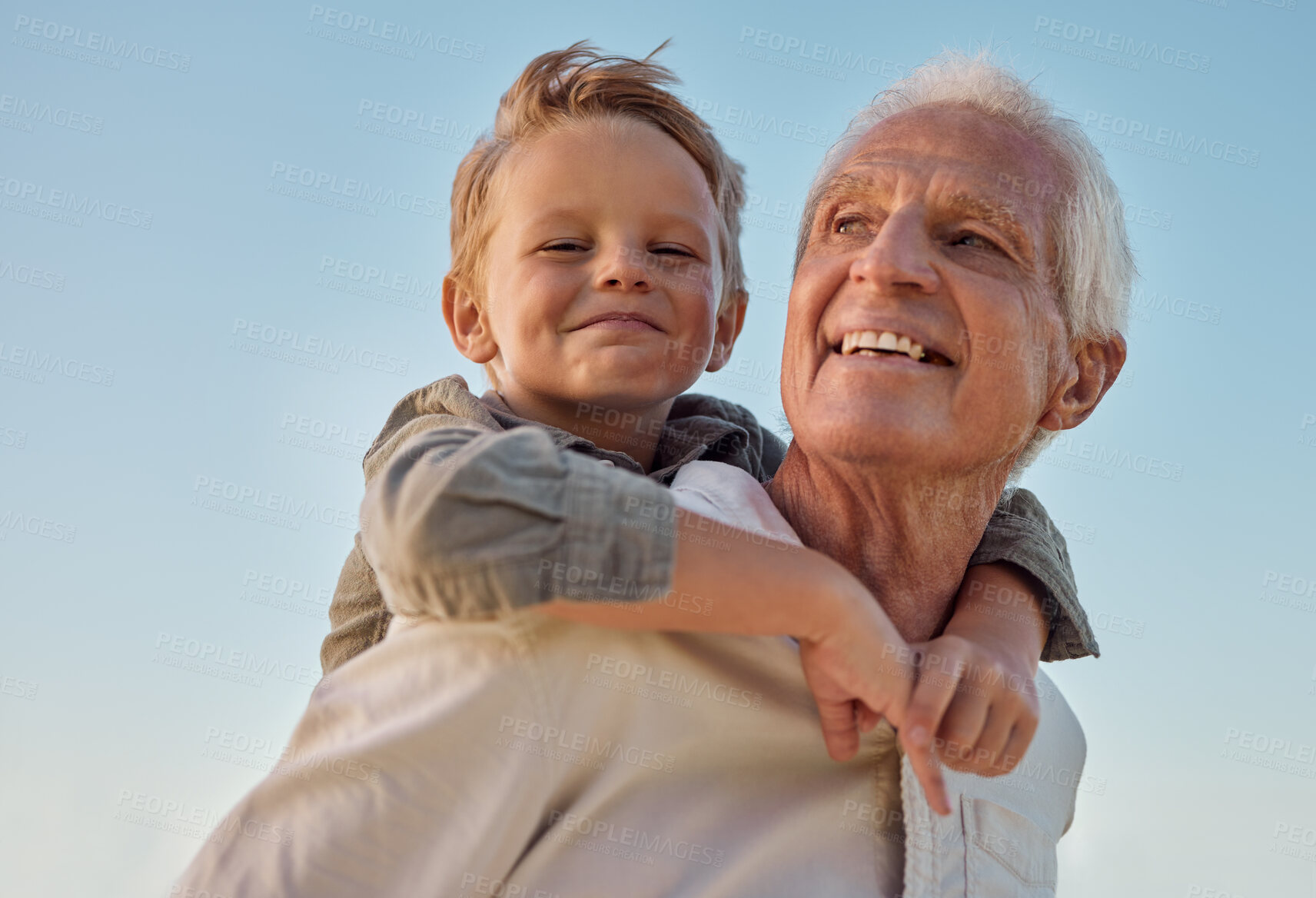 Buy stock photo Piggyback, child and grandfather with smile in nature for freedom, love and relax with a blue sky. Portrait of a young, happy and playful kid being funny, bonding and crazy with a senior man in park