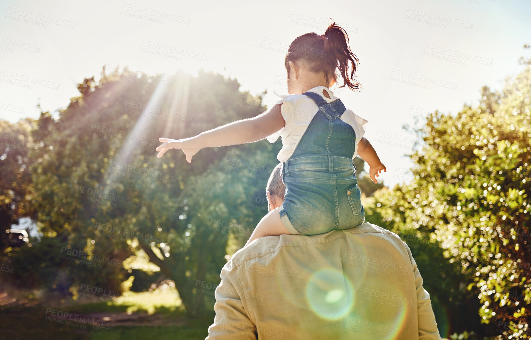 Buy stock photo Back, child and father walking in a park for freedom, care and love together in summer. Girl and dad on an adventure walk in nature, garden or backyard while carrying kid on shoulders with flare