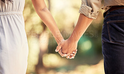 Buy stock photo Hand, love and couple with a man and woman holding hands outdoor in care, trust and relationship. Zoom in of a male and female walking outside together for romance and affection with trust in forest
