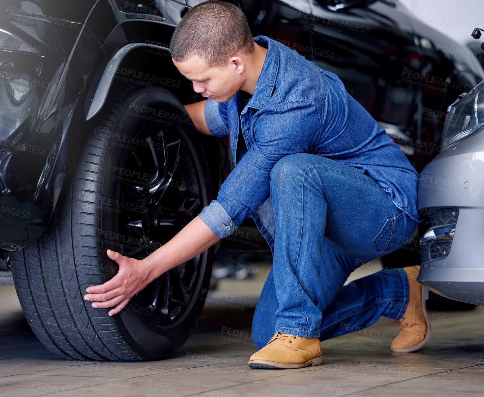 Buy stock photo Man, car mechanic and tire change in garage, vehicle maintenance or service. Expert, professional and repairman in automobile workshop or auto shop working on wheel, tyre repair or safety inspection
