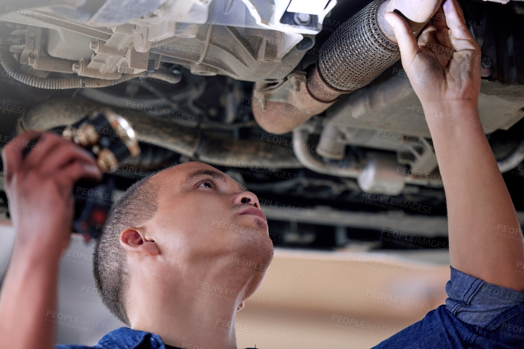 Buy stock photo Car, mechanic in garage and service inspection of motor vehicle for maintenance or safety. Auto shop, automobile workshop engineer and repairman working with torch to check vehicle pipe for oil leak 