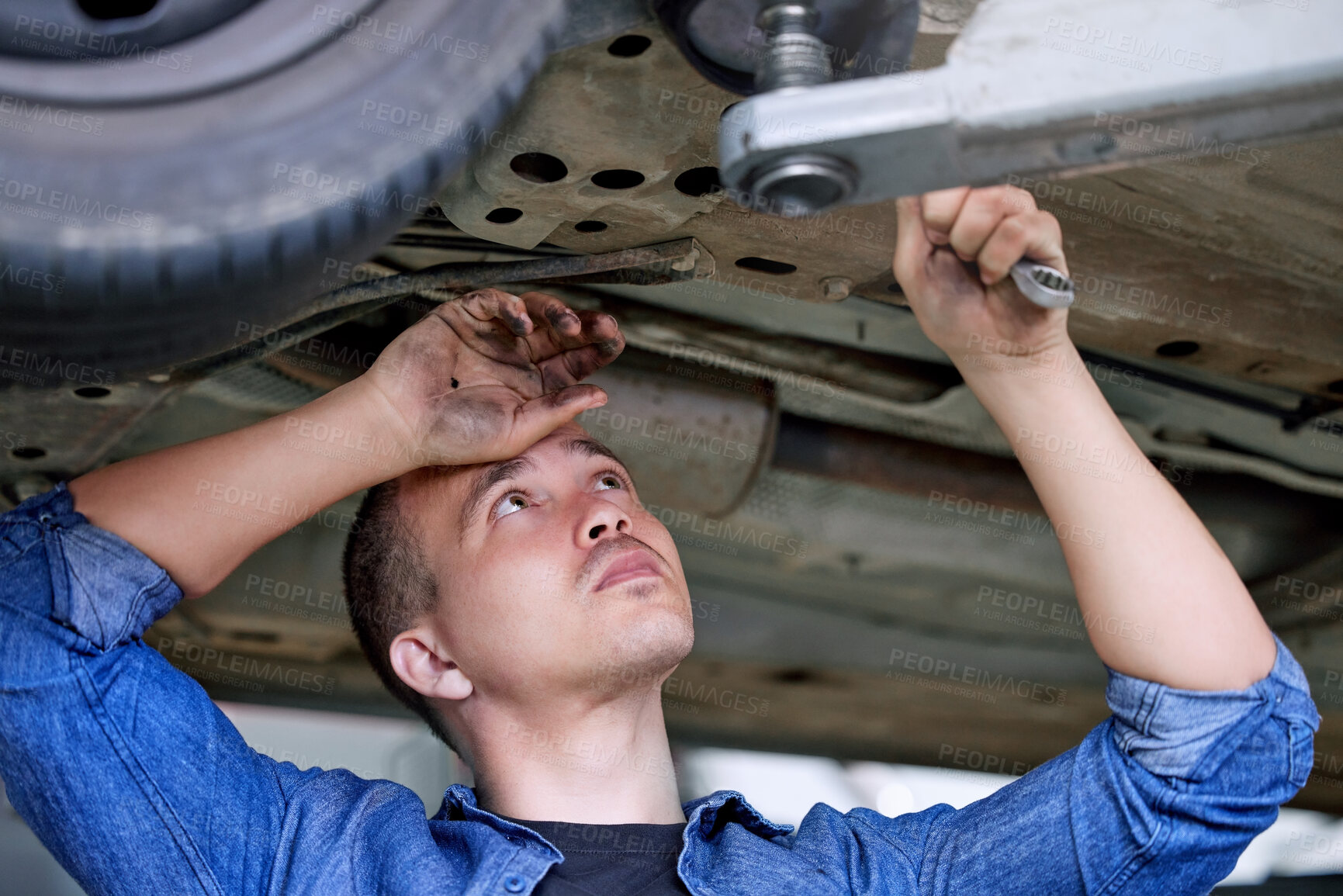 Buy stock photo Car service, repair and mechanic working on car in the garage or workshop. Motor care, engineer and repairman standing under vehicle with wrench doing inspection, maintenance and fixing automobile