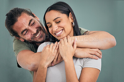 Buy stock photo Love, hug and support of a couple in a home with smile, care and affection. Trust, help and embrace of marriage or young interracial people, comforting partner together in their house with happiness
