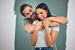 Happy, couple and hug for love, home improvement and smile against a painted wall background. Man and woman smiling for creative interior design in relationship, painting or house renovation together