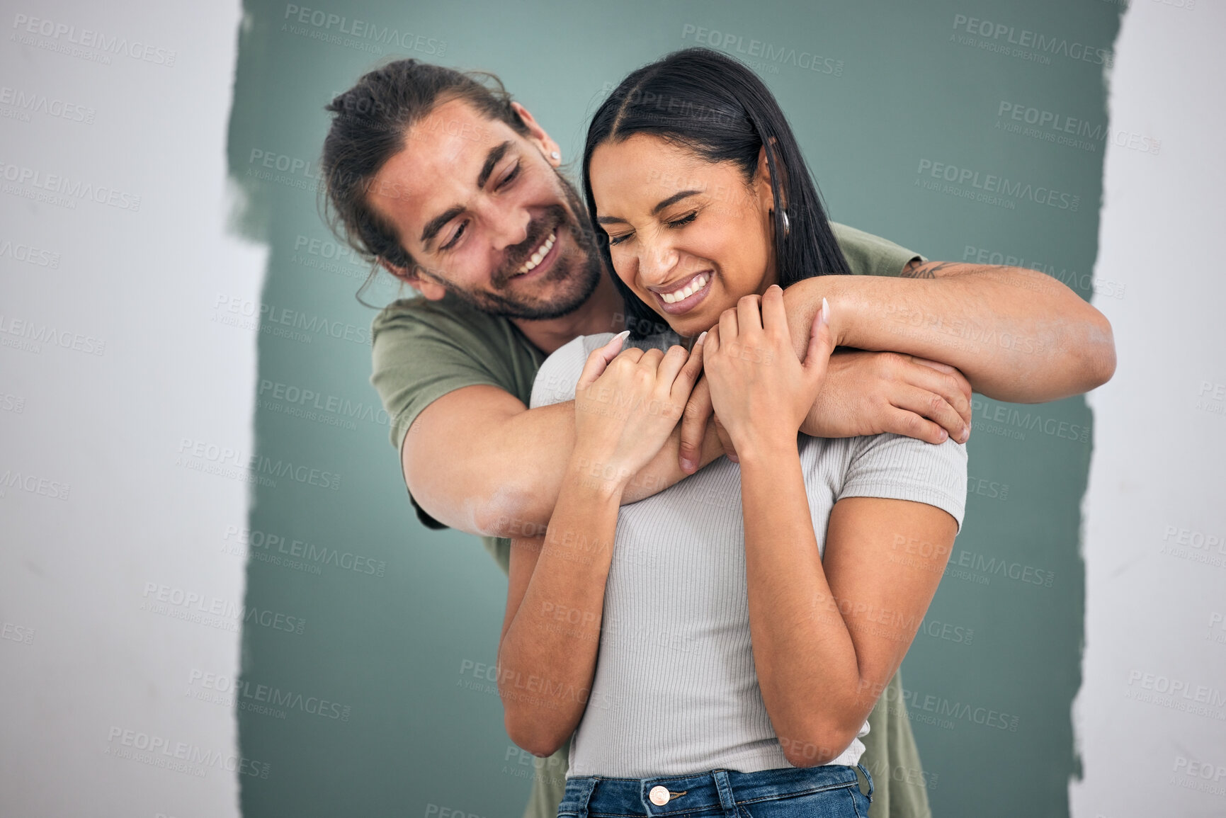 Buy stock photo Happy, couple and hug for love, home improvement and smile against a painted wall background. Man and woman smiling for creative interior design in relationship, painting or house renovation together