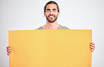 Mockup, advertising and man with yellow poster for text, announcement and message. Marketing, design and guy holding bright cardboard banner in hands with copy space, blank and empty space in studio