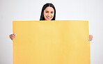 Woman with yellow mockup poster for advertising, marketing and product placement on blank cardboard. Happy, smile and a model in studio with sign board in hands for text, brand or logo advertisement.