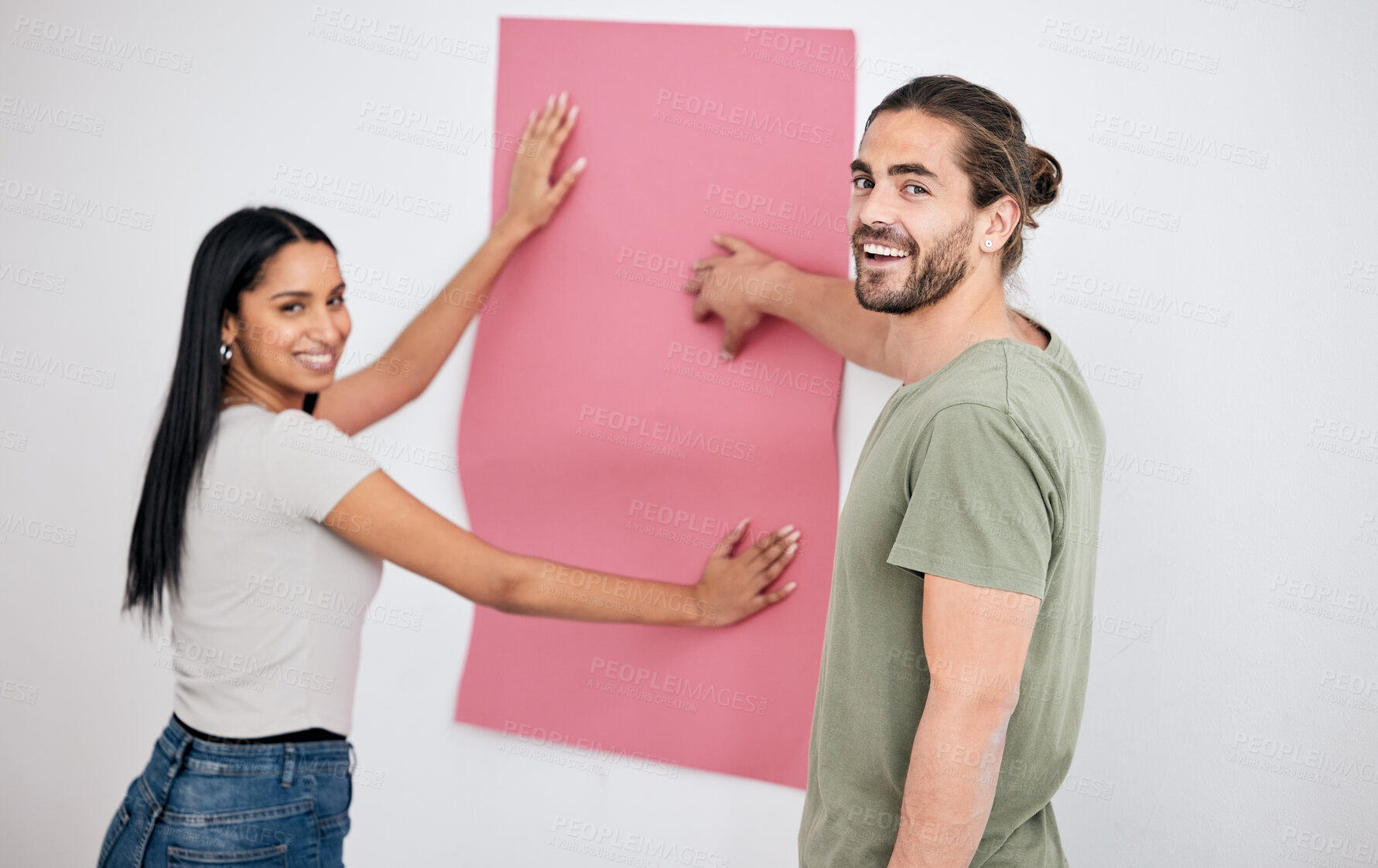 Buy stock photo Couple, wallpaper and home, design or renovation with pink poster. Smile, diversity and happy man and woman with banner or paper sheet for decoration, remodeling or renovating in house together


