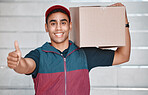 Thumbs up, success and courier with a delivery, box or ecommerce stock at a house. Portrait of a happy young man with a thank you, trust and smile for working in logistics service with cargo