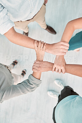 Buy stock photo Hands, collaboration and unity with a business team holding arms in an office together from above. Trust, support and teamwork with a man and woman employee group standing in solidarity or faith