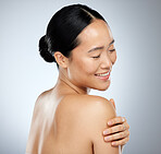 Skincare, beauty and body care with a model asian woman in studio on a gray background for natural wellness. Cosmetic, treatment and skin care with an attractive woman posing to promote a product