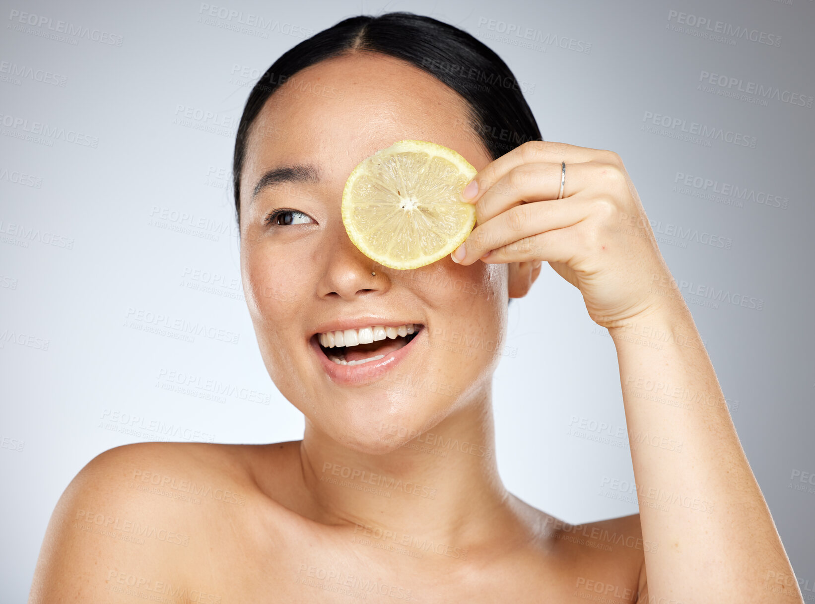 Buy stock photo Portrait, happy and woman using lemon for facial skincare cleaning, vitamin c and cosmetic benefits in studio in Tokyo. Smile, fruit and young Asian beauty model cleaning a glowing face for wellness